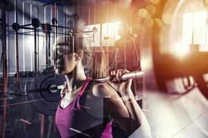 Athletic girl works out at the gym with a barbell. Female, healthy. Double exposure photo