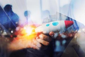 Businessman launches his startup company. Hand holding a wooden rocket. double exposure with light effects photo