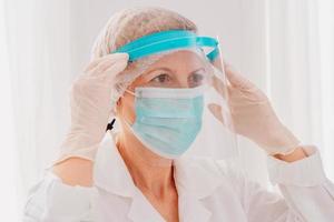 Doctor adjust the face protector screen against covid-19 virus photo