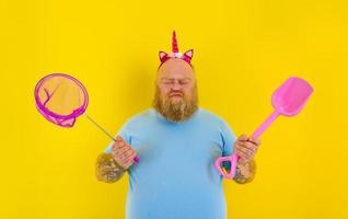 fat man with headband play with sea net and paddle photo