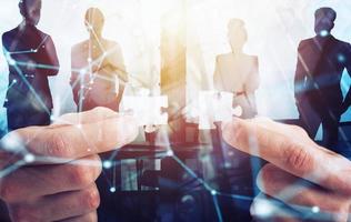 Businessman join two puzzle pieces. Concept of teamwork and partnership. double exposure with light effects photo