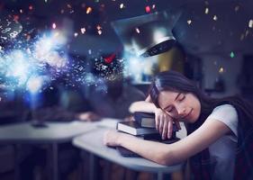 Tired girl sleeps over books and dreams of graduating. Concept of graduation and determination photo