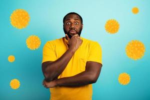 Fearful expression of a boy who is scared to catch the coronavirus. Cyan background. photo