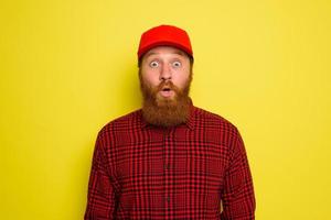 Delivery man with hat and beard has an wondered expression photo