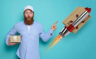 Courier man with surprised and amazed expression. concept of express and priority shipment. yellow background photo