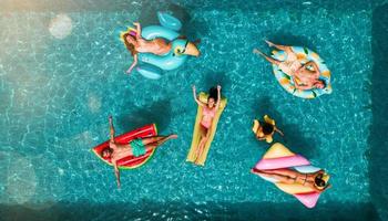 amigos en traje de baño en el piscina consiguiendo un bronceado foto