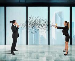 Two collegues screaming each other with megaphone in office photo