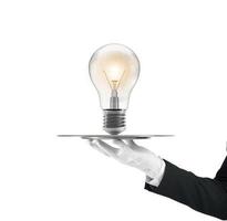 Waiter that holds a tray with a lightbulb. Concept big idea photo