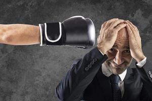 Businessman receives fists from competitors. concept of difficult career photo