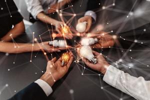 Teamwork and brainstorming concept with businessmen that share an idea with a lamp photo