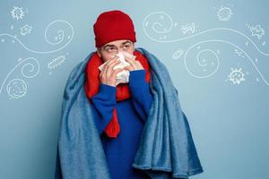 Boy caught a cold and uses pills to heal. Studio on Cyan background photo