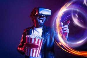 Man with VR glasses and popcorn watches a 3D film photo