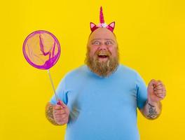 Fat happy man with headband play with sea net photo