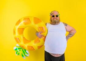 Fat delusion man with wig in head is ready to swim with a donut lifesaver photo