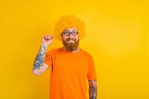 contento hombre con barba, amarillo peluca y lentes foto