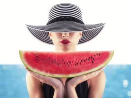 Girl in swimsuit with red watermelon in hand photo