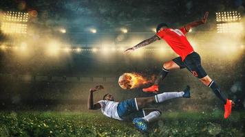 Soccer scene at night match with player in a red uniform kicking a fiery ball with power photo