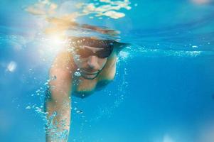 Sporty man swims fast in the sea photo