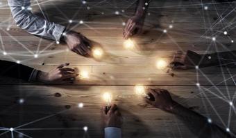 Teamwork and brainstorming concept with businessmen that share an idea with a lamp. Concept of startup photo
