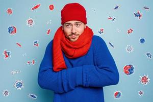 Boy caught a cold and is surrounded by viruses and bacteria. Studio on Cyan background photo