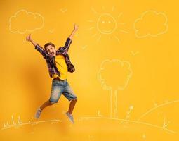 Happy and emotional child jumps over a yellow background. photo
