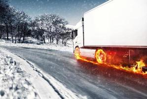 White truck with fiery wheels on a snow covered road photo