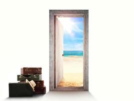 Door on white background leading to the beach with luggage on the floor. photo