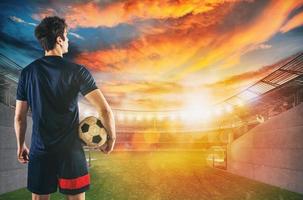 Soccer player ready to play with ball in his hands at the exit of the locker room tunnel photo