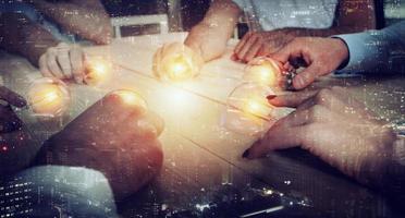Teamwork and brainstorming concept with businessmen that share an idea with a lamp. Concept of startup photo