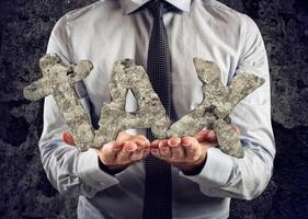 Businessman holds in hand the inscription tax made of heavy stone photo