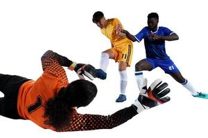 Goalkeeper catches the ball in the stadium during a football game. photo