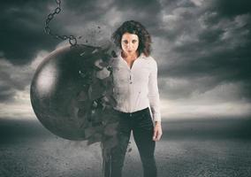 Power and determination of a young business woman against a wrecking ball photo