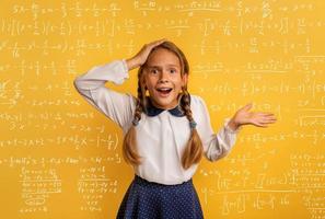 Young student is amazed about the difficulty of math problem. Yellow studio background photo