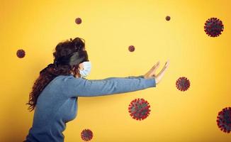 Woman with mask and blindfold. concept of uncertainty. yellow background photo