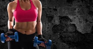 Athletic woman training biceps on grunge background photo