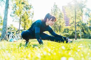 mujer lo hace gimnasio extensión ejercicios al aire libre en un soleado día foto