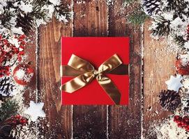 Christmas gift box presented in the middle of Christmas decorations on wooden planks photo