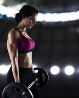 Athletic woman training biceps at the gym photo