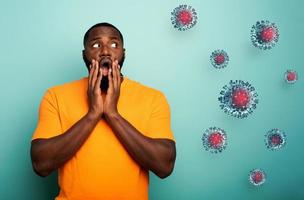 Fearful expression of a boy who is scared to catch the virus. cyan background photo