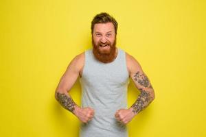 Man with beard and tattoos shows with pride his muscle photo