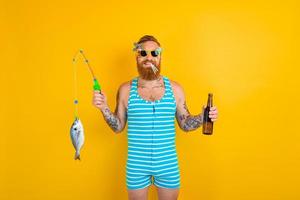 hombre con barba y traje de baño atrapado un pescado foto