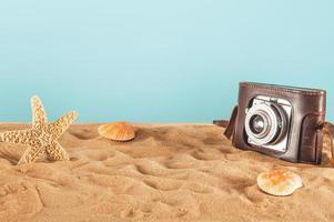 Background of beach with seashells, starfish and a retro photo camera