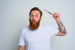 Wondered man with scissors is ready to cut the beard photo