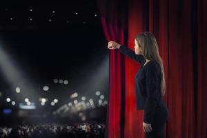 Woman open red curtains of the theater stage photo