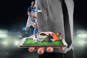 Real soccer players that are displayed on a cellphone during a match photo