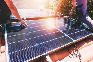 Workers assemble energy system with solar panel for electricity and hot water photo