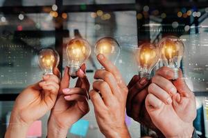 Teamwork and brainstorming concept with businessmen that share an idea with a lamp photo