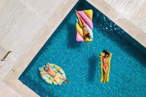 Friends in swimsuit in the pool getting a tan photo