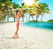 Surfer girl in a tropical beach photo