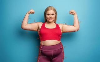 Determinated girl wants to remove fat and does gym at home. satisfied expression. cyan background photo